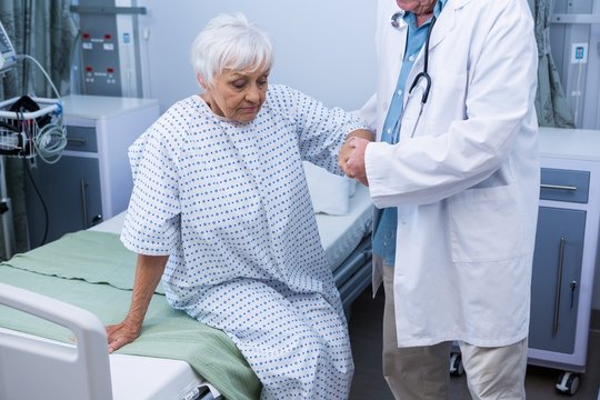 Doctor assisting senior patient at hospital
