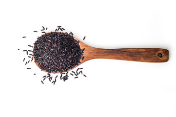 Black raw rice on wooden spoon on white background