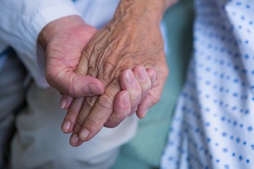 Doctor consoling senior patient in hospital