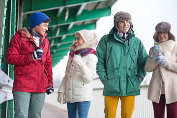 Multiethnic friends in winter wear conversing outdoors