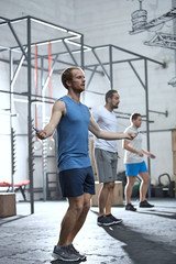 Full-length of men exercising in crossfit gym