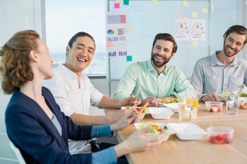 Smiling business executives having meal in office