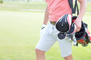 Fototapeta premium Midsection of man carrying golf club bag at course