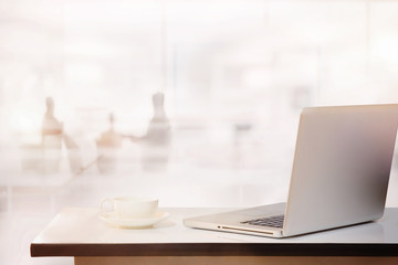 office desk with laptop and business office background.
