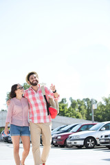 Obraz premium Happy couple walking on city street against clear sky