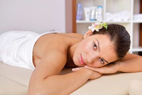 Portrait of young woman relaxing on massage table