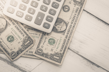 Calculator with american dollars on the wooden table background, finance concept