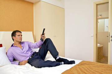 Man on bed with remote control