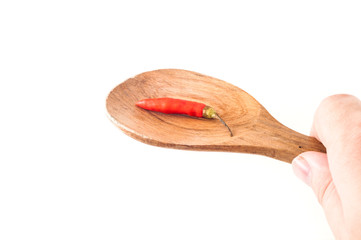 Small red chili pepper on wooden spoon