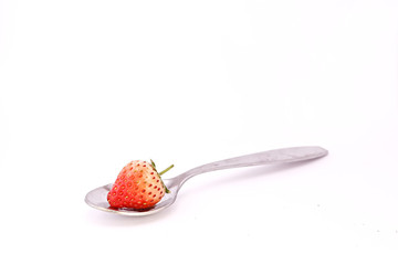 Strawberry on spoon isolated white background
