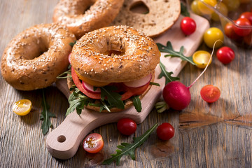 Vegetarian bagel sandwich with fresh veggies and arugula, healthy vegan snack