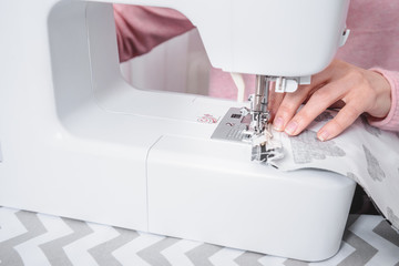 beautiful woman seamstress sew on the sewing machine clothes.