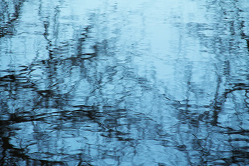 Fototapeta na wymiar abstract photo of dark reflections on the blue water surface useful as background