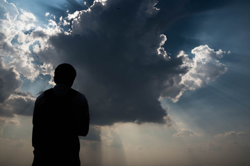 Silhouette of man and sky with sunlight