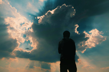Silhouette of man and sky with sunlight