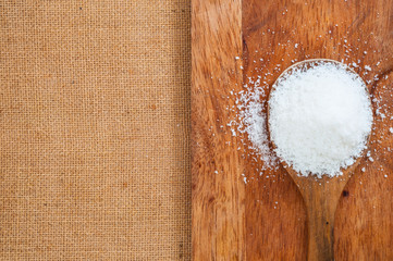Fototapeta na wymiar Salt or sweet sugar in wooden spoon on wood desk