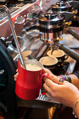 Preparing the coffee and cappuccino at the espresso machine.