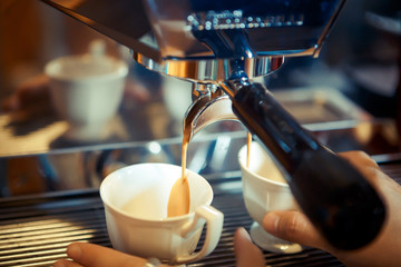 espresso machine pouring fresh coffee into cups