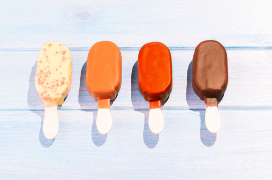 Four different ice creams on blue table outdoors