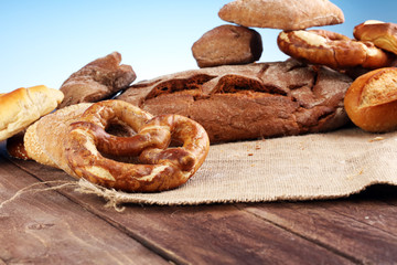 Different kinds of bread and bread rolls on board from above. Kitchen or bakery poster design.