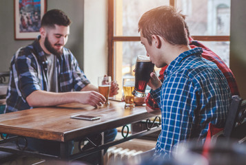 Group of Hipster Friends drinking beer and talking at the bar
