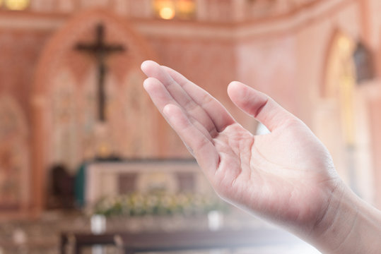 Human open empty hand with palms up(Praying Hand) on blurred church interior background