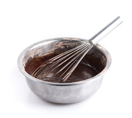 Whisk with bowl and chocolate dessert for cooking on white