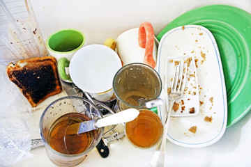 Sloppy messy grungy sink filled with dirty dishes and food.