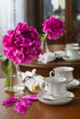 White cup of tea and peony flower