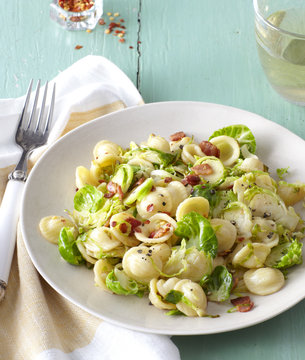 Orecchiette pasta with brussels sprouts and bacon in a bowl.