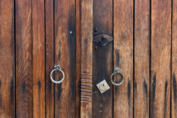 Wooden brown door of planks with metal handles and keyhole