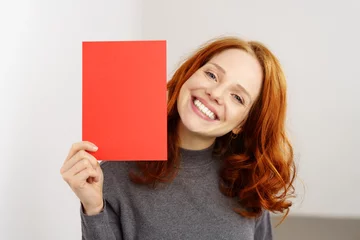 Fotobehang frau zeigt lachend eine rote karte © contrastwerkstatt