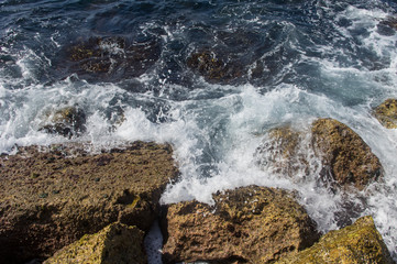 Waves breaking on the rocks of the breakwater, background.