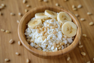 Healthy eating. Cottage cheese with banana and pine nuts.