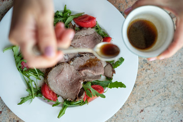 Healthy food. Salad from arugula, tomatoes and roast beef.