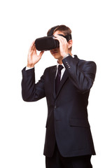 Young handsome businessman in black suit wearing virtual reality goggles., isolated on white background