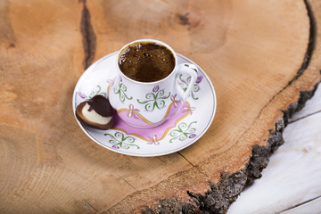 Turkish coffee with heart shaped chocolate on wooden 