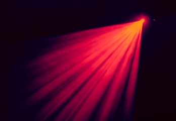 The red light from the spotlights through the smoke at the theater during the performance. Lighting equipment.