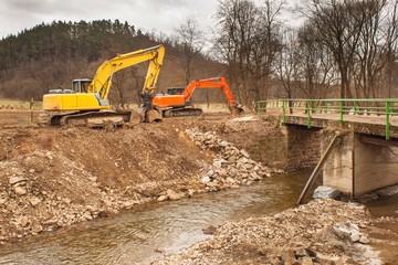 Flood adjustments river. Work on the riverbed. Excavator on the work to strengthen the shoreline of the river.