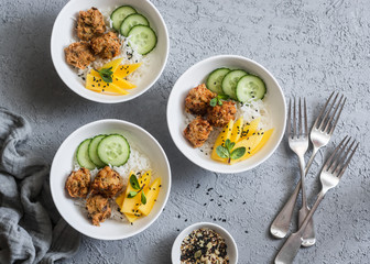 Crispy fried fish tacos with rice and mango on a gray background, top view. Asian style food
