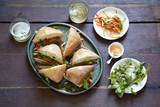 Tofu bahn mi sandwich platter with beer and sides.