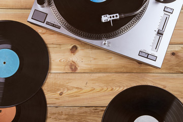 Gramophone with a vinyl record on wooden table, top view