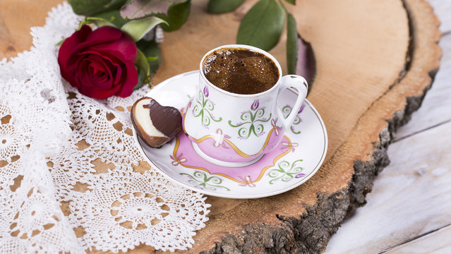 Turkish coffee with hearth shaped chocolate, red rose on the lace cover 
