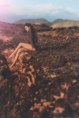 Pretty girl sitting on mountain top