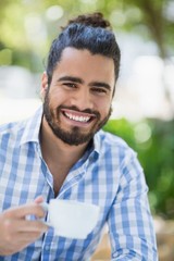 Man holding coffee cup in the park on a sunny day