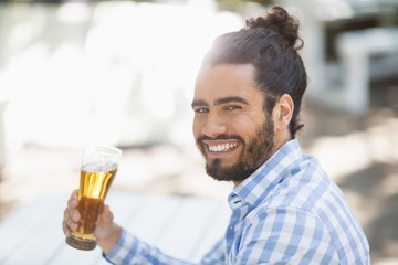 Man holding beer glass in the park on a sunny day