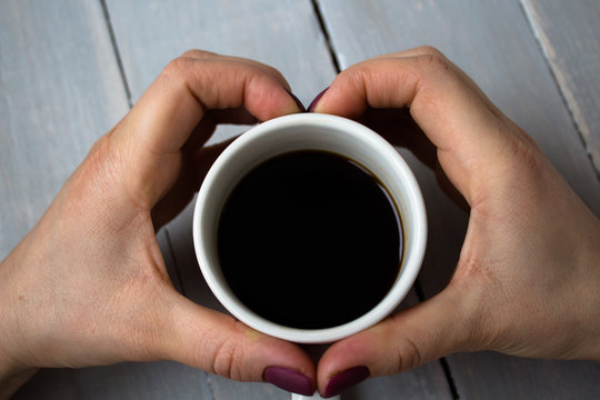 cup of coffee and hands in heart shape