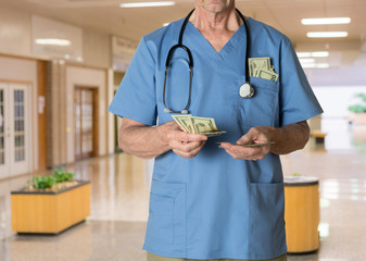 Senior doctor in scrubs counting cash
