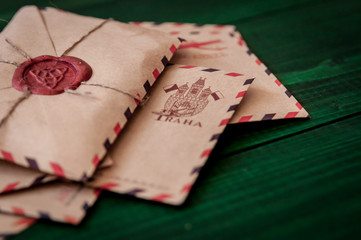 Old vintage retro envelopes with a wax stamp on old dark green wooden table