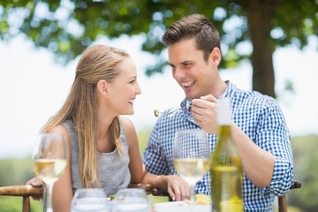 Man feeding food to woman
